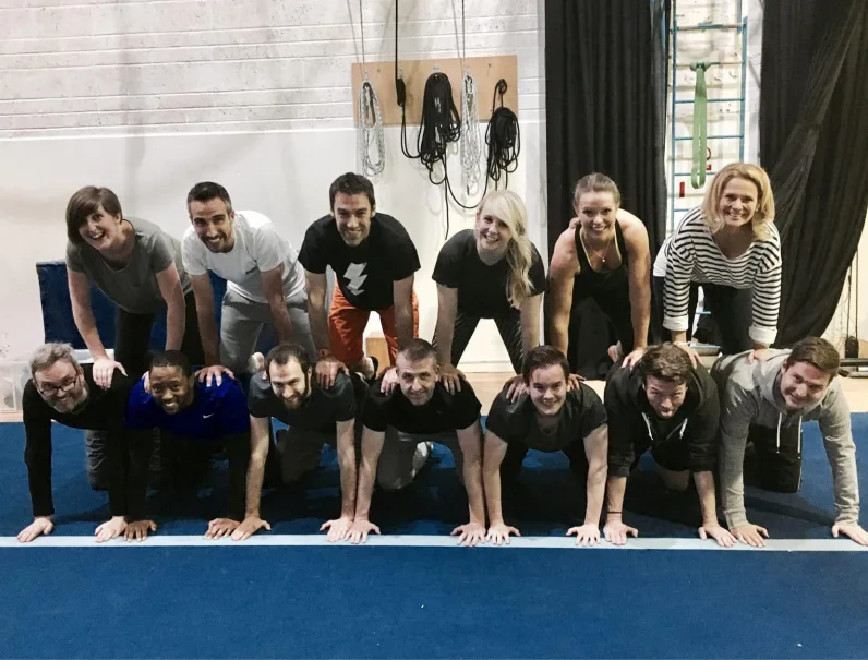 Team posing in a workout space, appearing to be part of a team-building activity