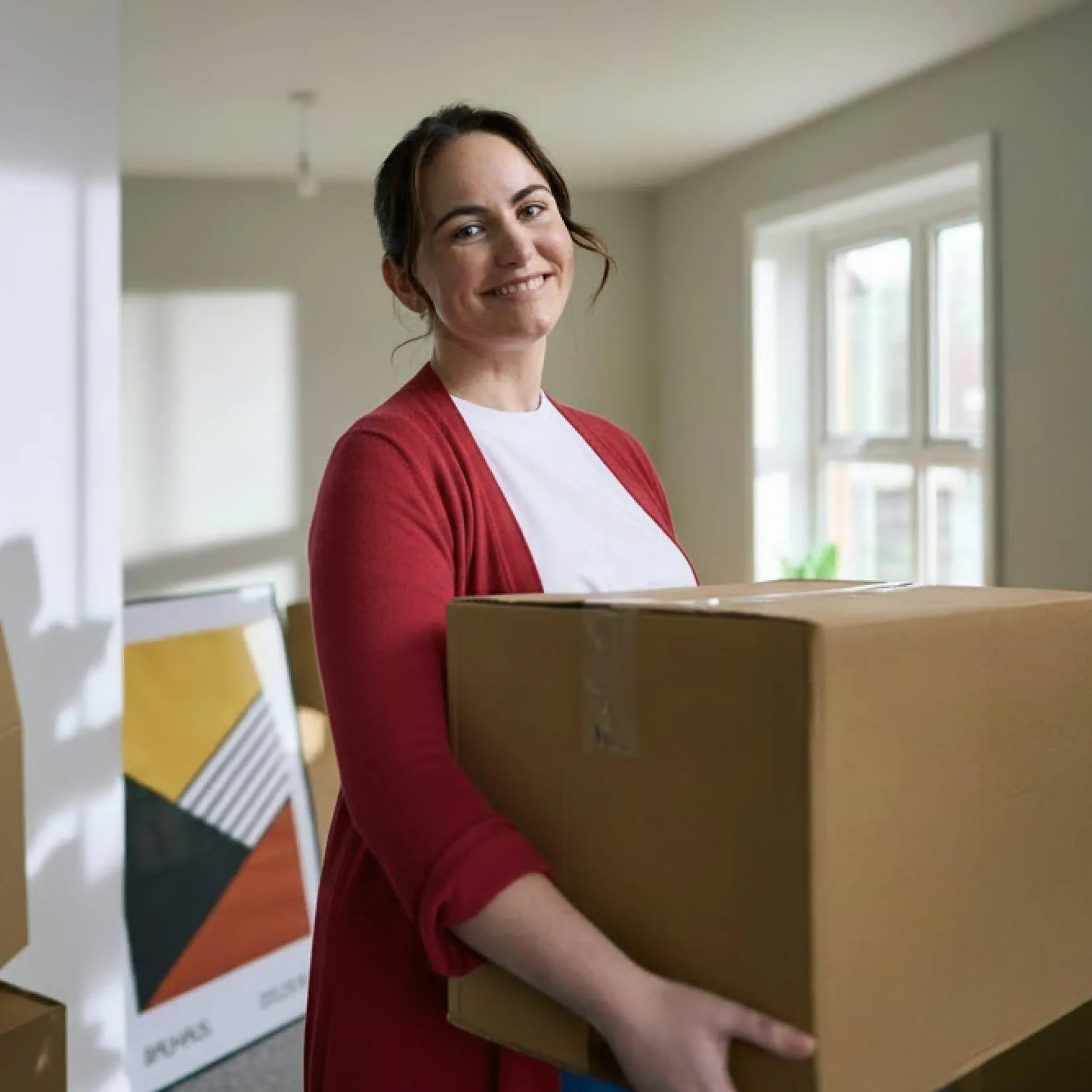 Woman carrying box moving into home