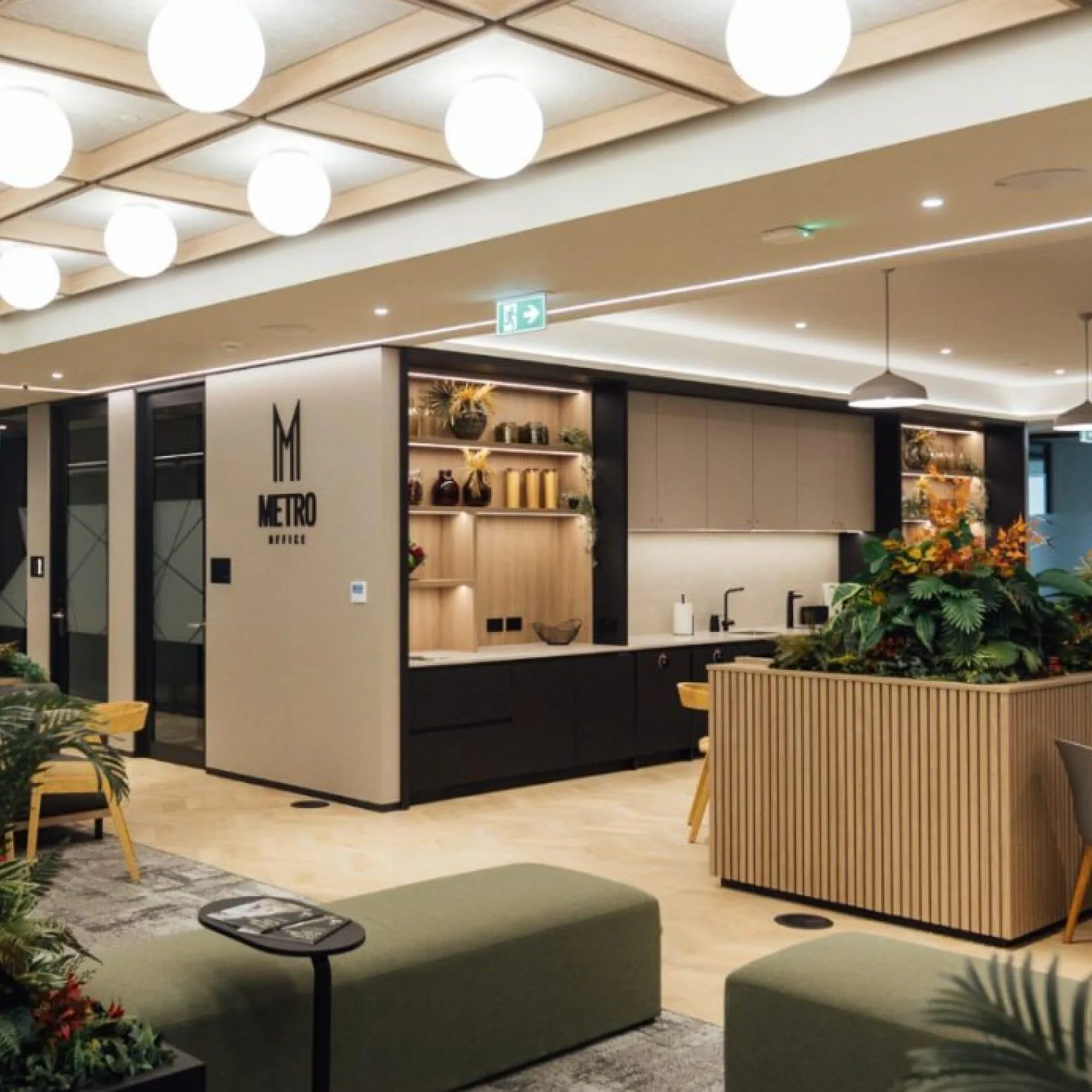 Modern interior fit-out featuring a reception area for Metro Office with custom joinery, seating, plants, and warm lighting.