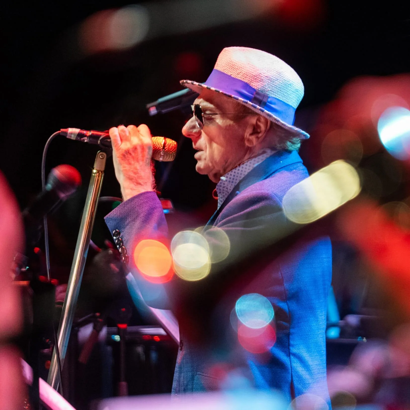 Van Morrison singing into microphone on stage